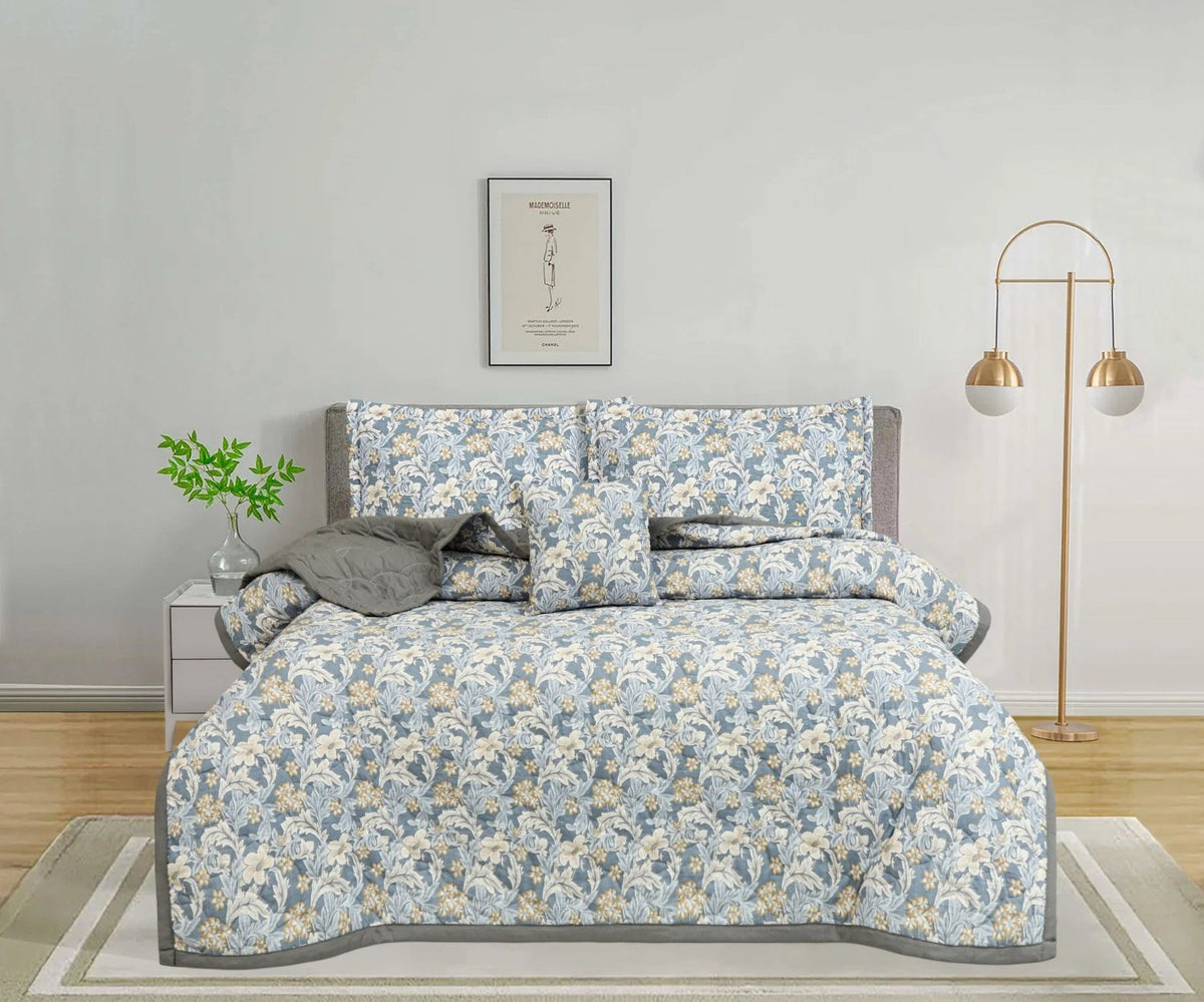 Blue and cream floral print bedspread set with matching pillowcases in a modern bedroom