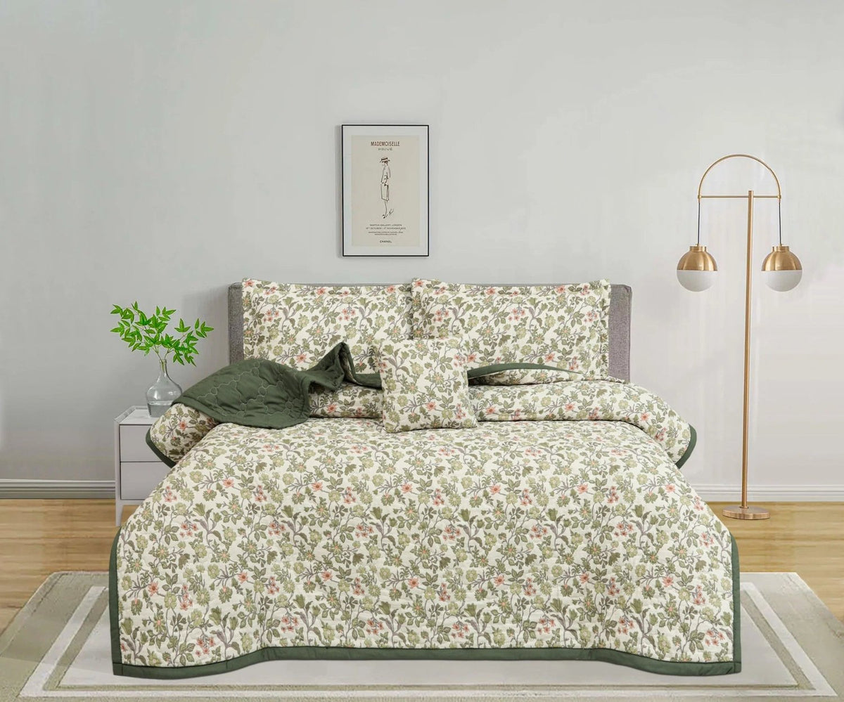Floral print bedspread set with matching pillows and green accent throw in a modern bedroom