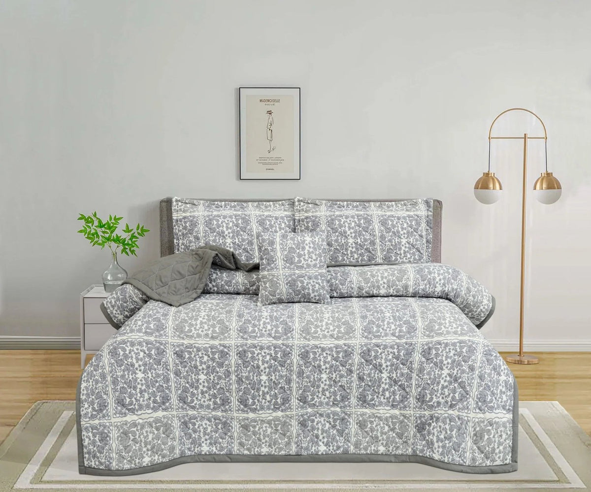 Grey and white floral print bedspread set with matching pillowcases in a modern bedroom.